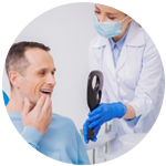 Dental Patient Observing His New Smile As Doctor Holds Up a Mirror